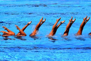 Legs sticking out of the water during artistic swimming routine